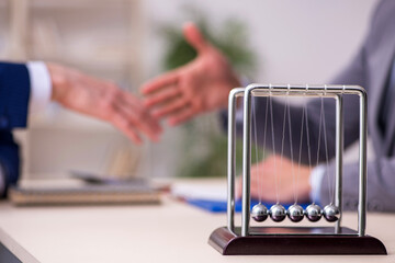 Two businessmen and meditation balls on the table