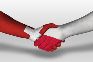 Handshake between poland and switzerland flags painted on hands, illustration with clipping path.