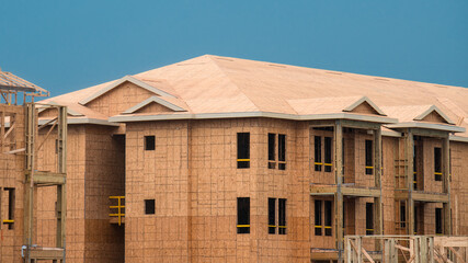Frame house. New residential construction home framing against a blue sky. Roofing construction. Wooden construction.