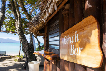 wooden beach bar sign outside on a tropical island