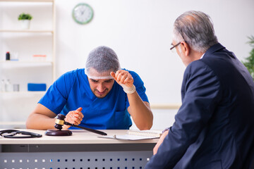 Male doctor in courthouse meeting with advocate