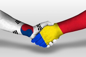 Handshake between romania and south korea flags painted on hands, illustration with clipping path.