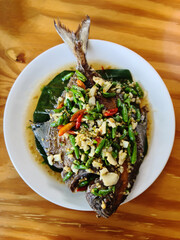 Deep fried fish with chili on a white plate