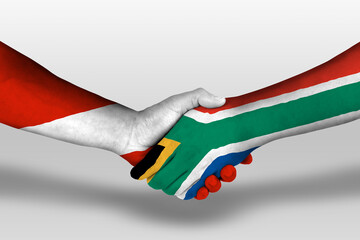 Handshake between south africa and austria flags painted on hands, illustration with clipping path.