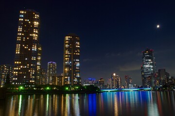Fototapeta na wymiar 月の浮かぶ隅田川夜景　高層ビル群と佃大橋ライトアップ