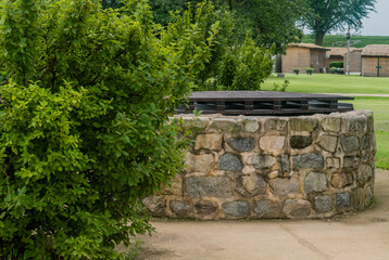 Side view of old stone water well with wooden cover