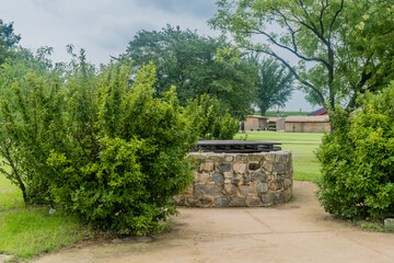 Side view of old stone water well with wooden cover