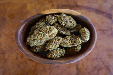 Close up of Cannabis in a wood bowl. wood background 