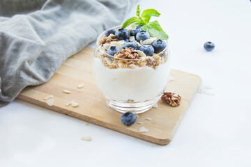 Healthy blueberry and walnut parfait in a glass on a white background