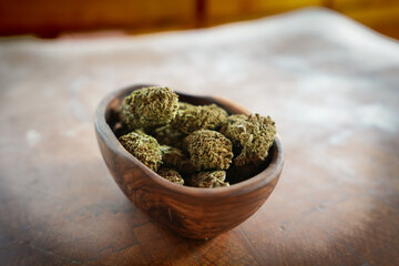 Close up of Cannabis in a wood bowl. wood background 