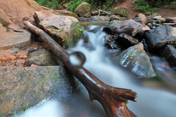 Obraz premium Natural background. Drop on the front lens of the lens. Flowing water of a forest stream. Photo with a long exposure