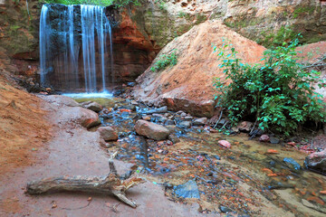 Waterfall in the forest. Natural background. Flowing water of a forest stream. Photo with a long exposure