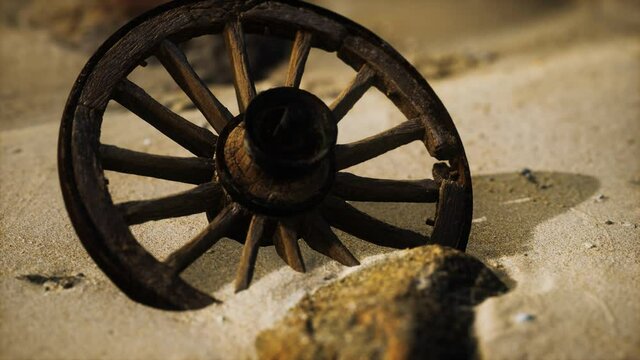 Large wooden wheel in the sand