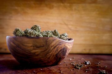 Close up of Cannabis in a wood bowl. wood background 