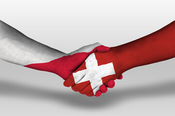 Handshake between switzerland and poland flags painted on hands, illustration with clipping path.