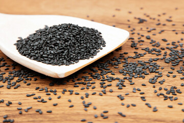Black sesame seeds in a wooden spoon For healthy food and diet concepts.