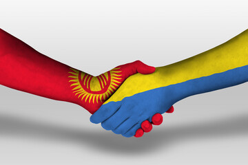 Handshake between ukraine and kyrgyzstan flags painted on hands, illustration with clipping path.