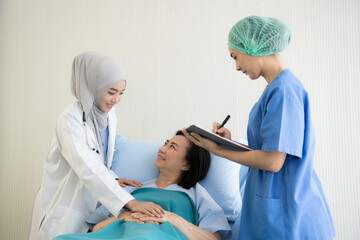 Asian female doctors examination and treating  female patient in a hospital room