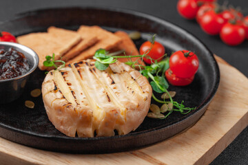 Hot appetizer baked camembert or brie cheese with jam