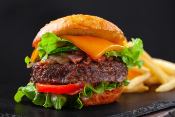 Beef burger with french fries, beef cutlet, cheese, vegetables