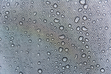 Fototapeta na wymiar Close-up shot of water droplets on the tent. Macro photography. Camping in spring, summer and autumn. Background with space for text.