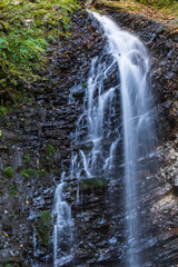 Mountain stream and rocky waterfall. Tourist and geological landmark. Waterfall Guk. Carpathians, Ukraine.