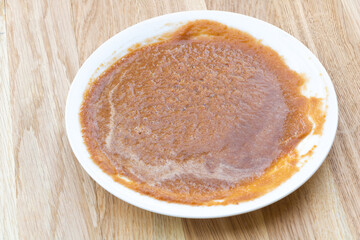Fresh and tasty apple jam in the plate, wooden background