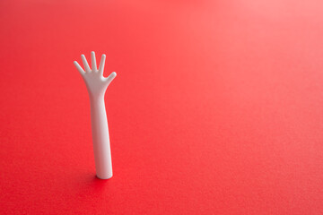 Help me please. Arm emerging in red background with copy space. Life or health insurance, investment protection and personal loan concept. Risk management analysis and planning.