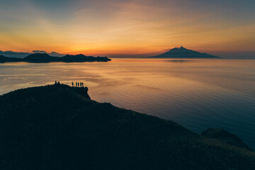 Padar island.Wild Indonesia. Flores. tropical paradise. Labuan Bajo. drone shooting. Wild beaches, aerial view. boat trip safari. a group of people watching the sunset on the hill. Vulcano view