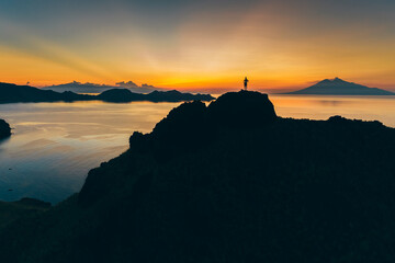 Padar island.Wild Indonesia. Flores. tropical paradise. Labuan Bajo. drone shooting. Wild beaches, aerial view. boat trip safari. one men watching the sunset or sunrise on the hill. Vulcano view