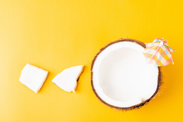 Happy coconuts day concept, fresh coconut and sun umbrella, studio shot isolated on yellow background, Beach tropical fruit spring summer holiday