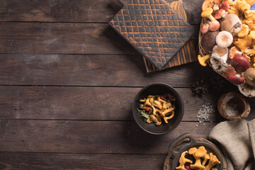 Autumn harvest of mushrooms on vintage rustic wooden background. Rustic kitchen table. Flat lay top, top view . Layout with free text space. Forest harvest concept.