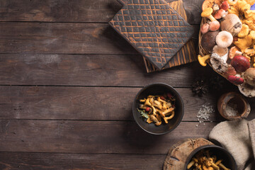 Autumn harvest of mushrooms on vintage rustic wooden background. Rustic kitchen table. Flat lay top, top view . Layout with free text space. Forest harvest concept.