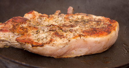 Roasted steak on the frying pan in the kitchen