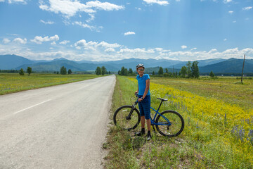 Obraz premium A young man on a mountain bike travels through the picturesque places of the Altai mountains.