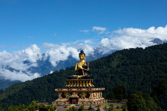  A huge statue of Lord Buddha in a sunny morning in Buddha Park with The Kanchenjunga snow peak in background in Sikkim in India