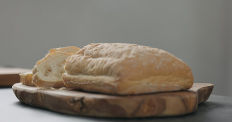 sliced freshly bakled ciabatta bread on olive board
