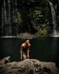 Male model in a waterfall in Bali Indonesia
