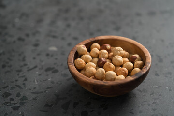 roasted hazelnuts in olive bowl on terrazzo countertop