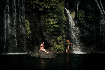 Two models in a beautiful waterfall in Bali Indonesia