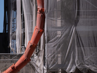Apartment building renovation with debris chute for construction debris and netting