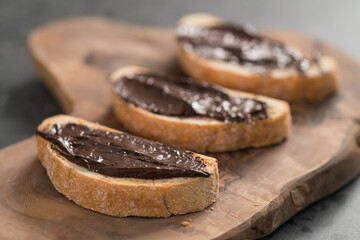Rustic ciabatta with organic chocolate cream on olive wood board