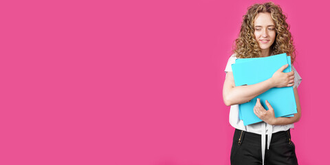 A young woman holds folders with documents in her hands.