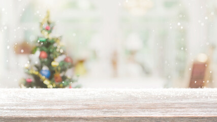 Empty wood table top on blur with bokeh Christmas tree and new's year decoration on window banner background with snowfall - can be used for display or montage your products.