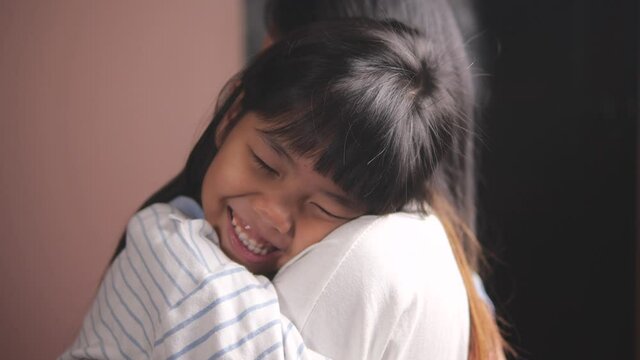 Happy cute affectionate adopted little Asian kid girl hugging foster care parent mother. Adorable small child daughter embrace mum cuddling enjoy tender sweet moment concept, 4K