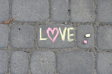 Lettering LOVE made iwith chalk on the road.