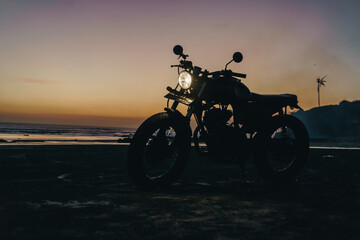 Fototapeta na wymiar Custom motorbike in the beach at sunset in Bali Indonesia