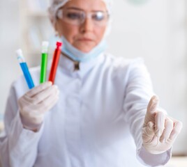 Woman chemist pressing virtual button in lab