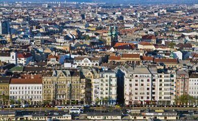Obraz premium Aerial cityscape in Budapest, one of the largest cities in EU. Photo was taken from Citadella in Budapest, Hungary. Nice houses roofs and the road with high traffic on the foreground.