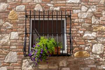 Typical Italian Window With Closed Wooden Shutters, Decorated With Fresh Flowers